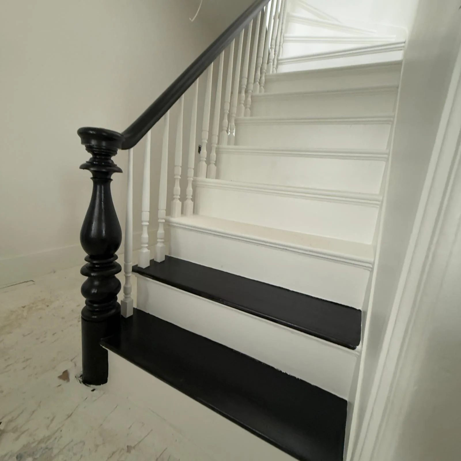 Black stair treads and handrail with white risers and balusters in a CRC project